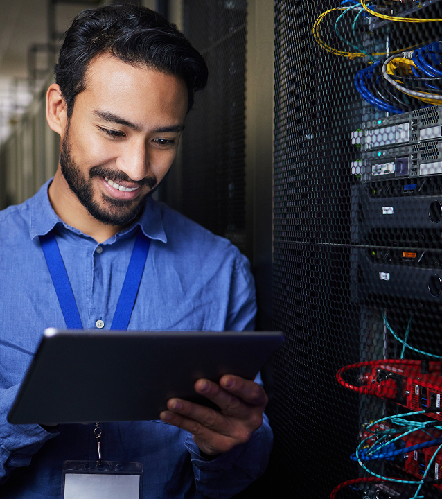 IT man looking at tablet in server room next to wiring